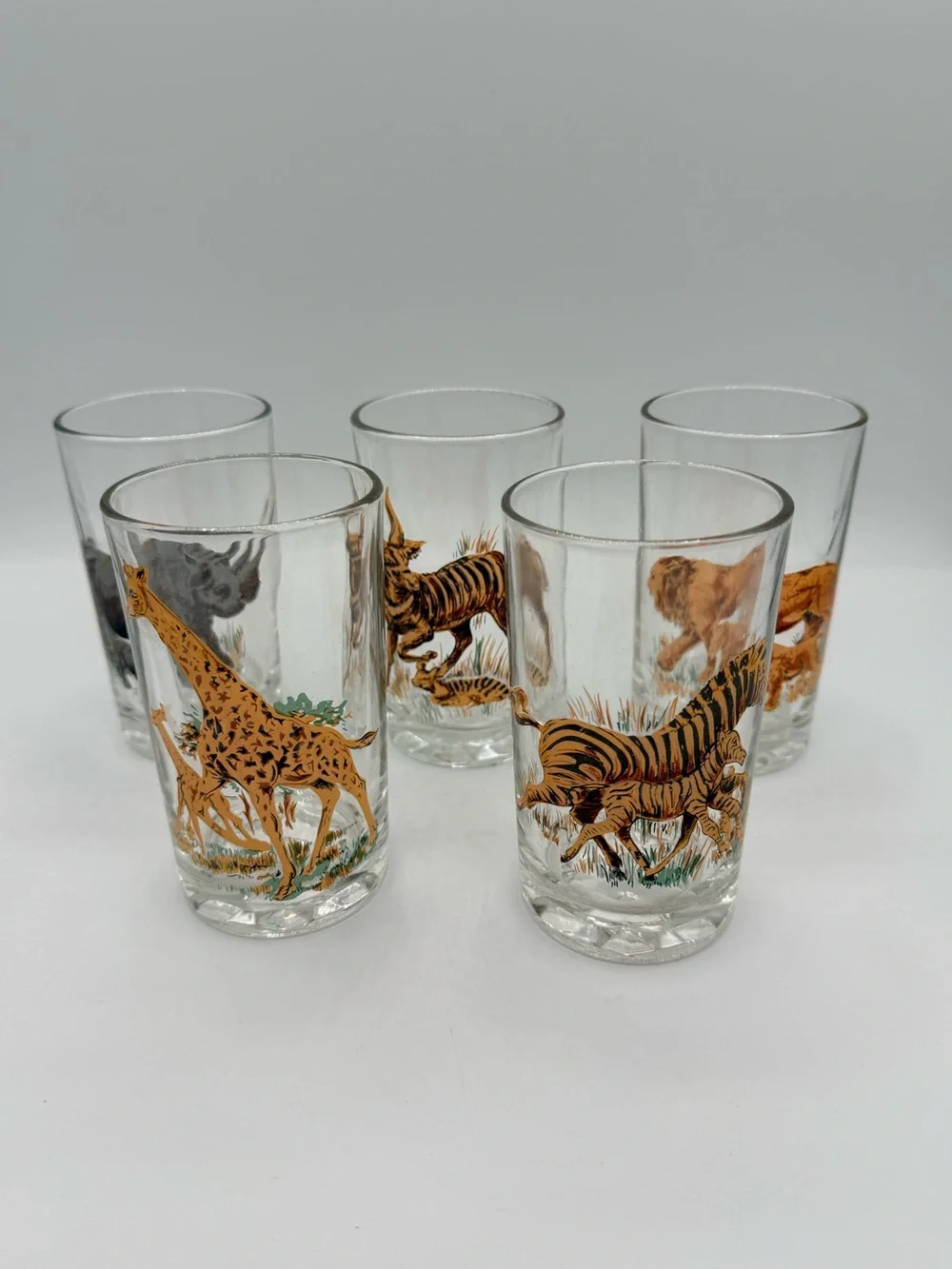 Set of five vintage Pasari glass tumblers with African wildlife decals.